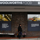 A woman walks past an outlet of retailer Woolworths in Cape Town, South Africa.